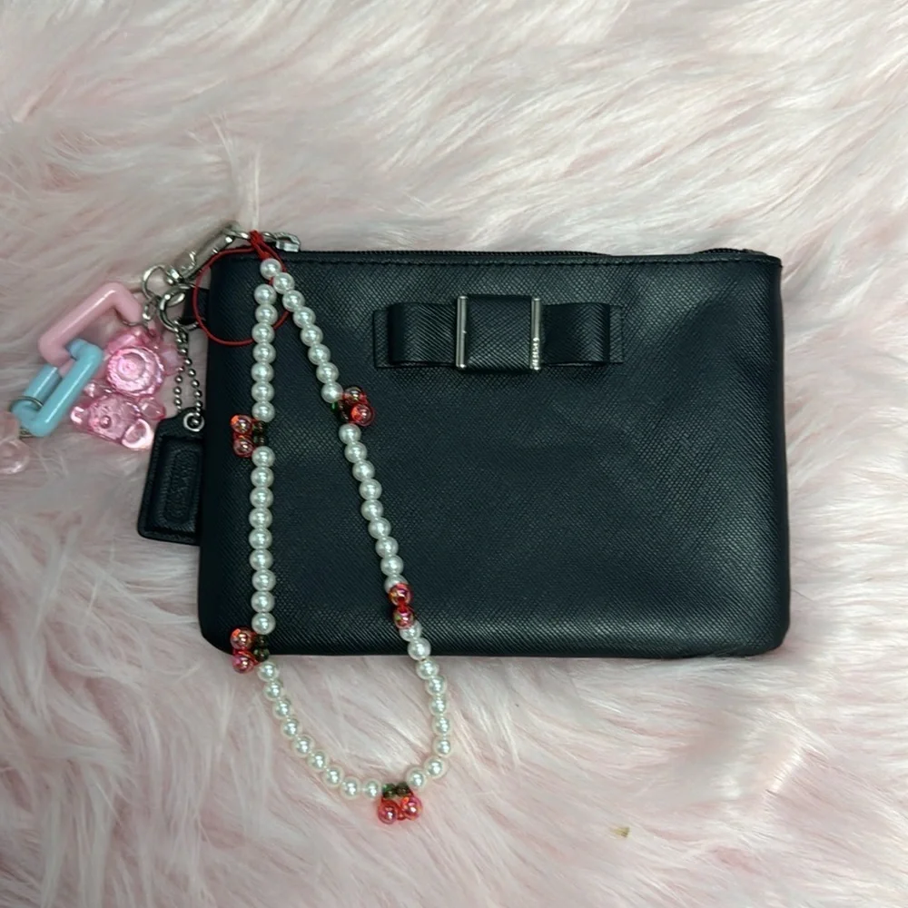 Elegant Black Women's Coach wristlet with bow coquette